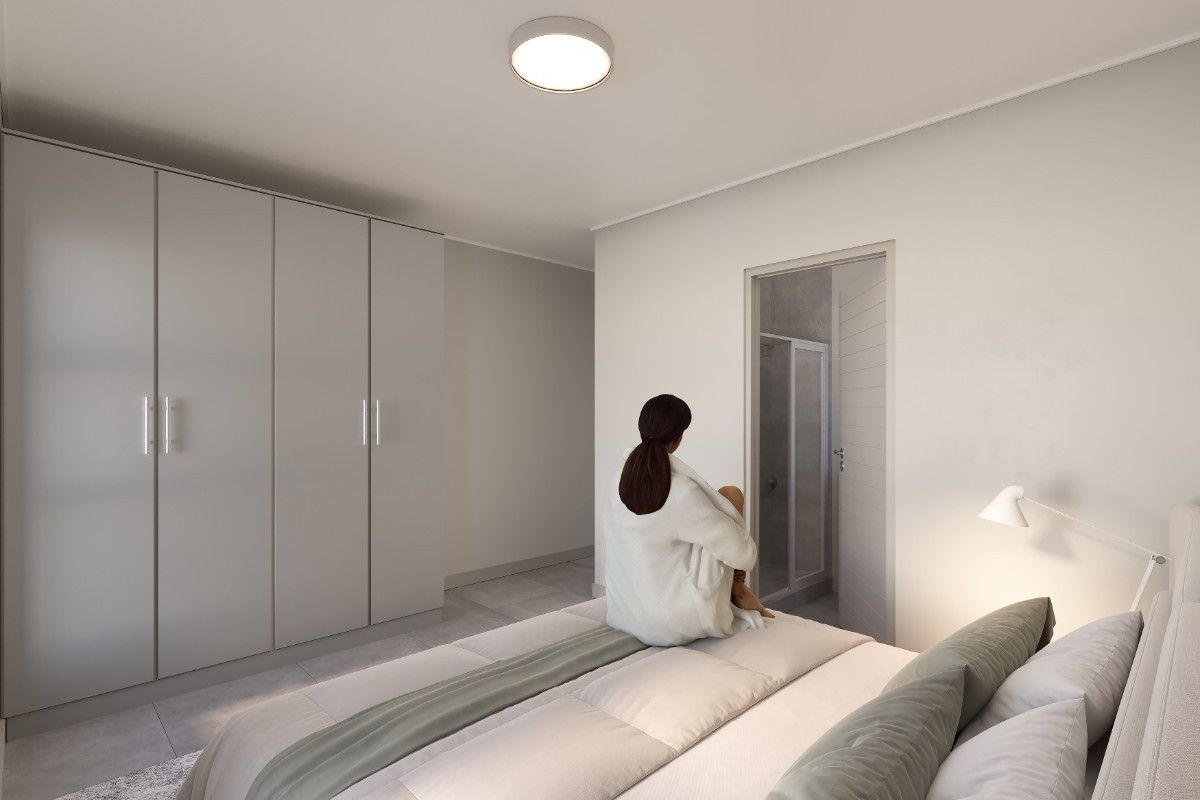 Modern bedroom featuring neutral tones, ample built-in wardrobe storage, and direct access to an en-suite bathroom.