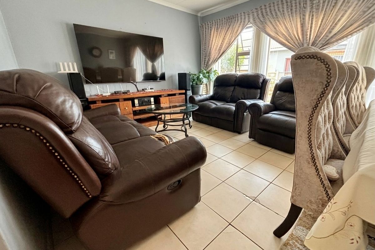 A comfortable living room featuring tiled flooring and coved ceilings, providing a functional space for relaxation and entertainment.
