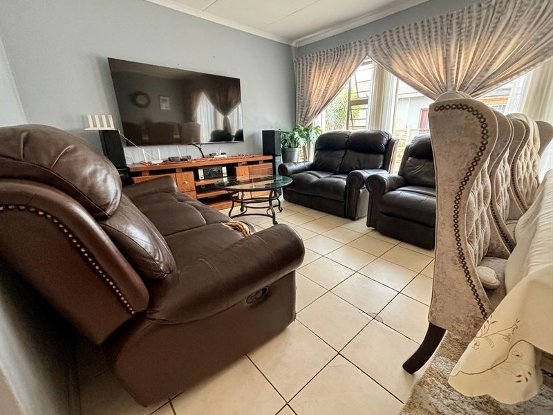 A comfortable living room featuring tiled flooring and coved ceilings, providing a functional space for relaxation and entertainment.