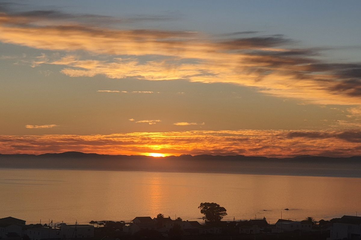 A scenic sunset view overlooking the ocean and coastal landscape, highlighting the property's desirable location and natural surroundings.