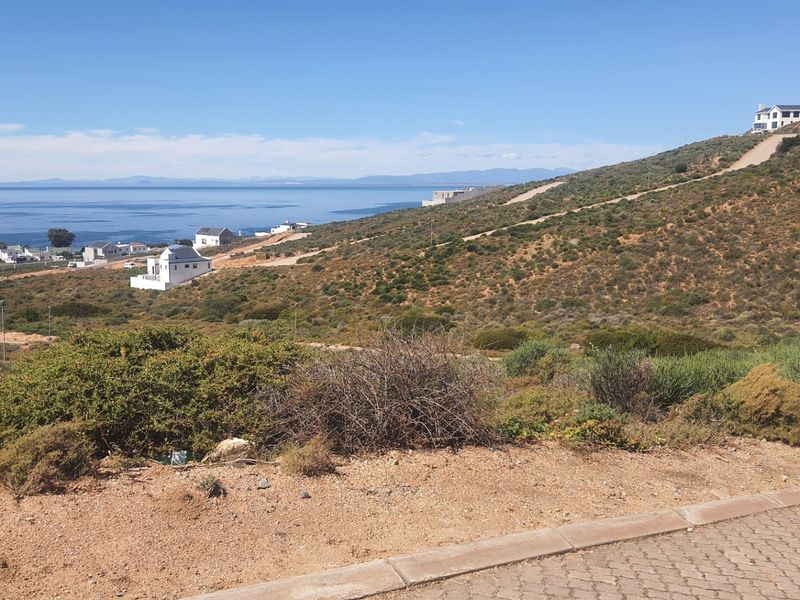 A scenic view of the coastal landscape and surrounding residential development from the vacant land plot.
