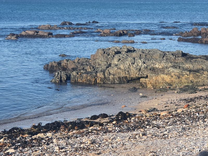 A scenic view of the rocky coastline and ocean, highlighting the natural waterfront features of the vacant land.