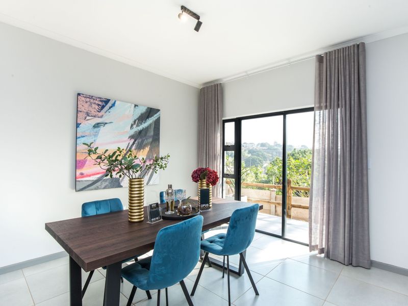 A bright dining area featuring tiled flooring, modern track lighting, and large sliding glass doors that provide access to an outdoor space.