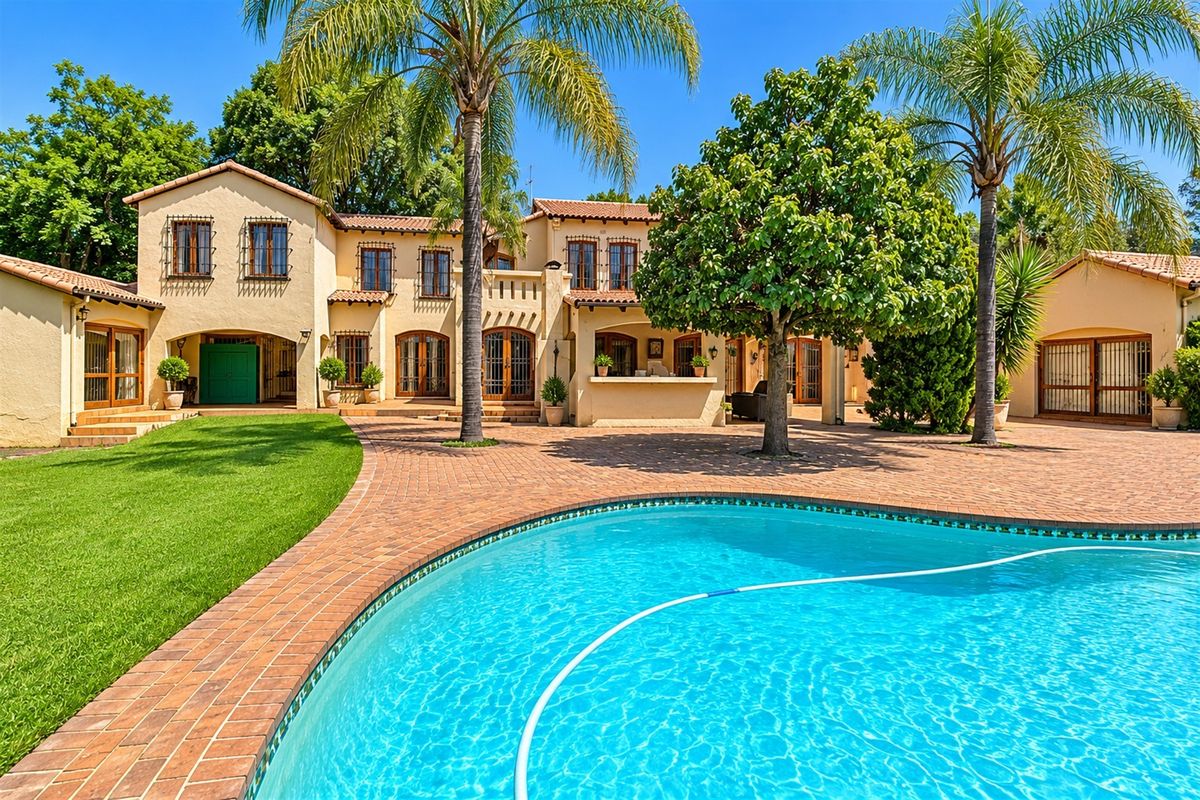 Spacious rear exterior featuring a large swimming pool, extensive brick-paved patio area, and a Mediterranean-style home with a built-in outdoor bar.