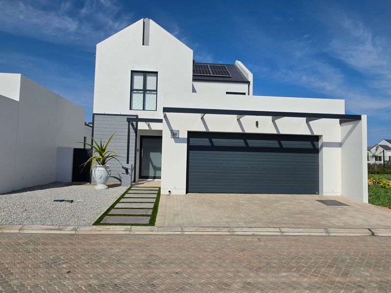 Modern double-story home featuring a clean white facade, integrated double garage, solar panels, and a neat paved driveway with a landscaped walkway.