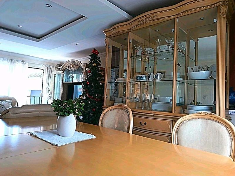 A dining room featuring a recessed ceiling and access to an outdoor patio area through a sliding glass door.
