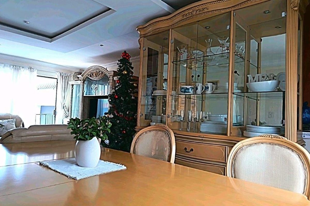 A dining room featuring a recessed ceiling and access to an outdoor patio area through a sliding glass door.