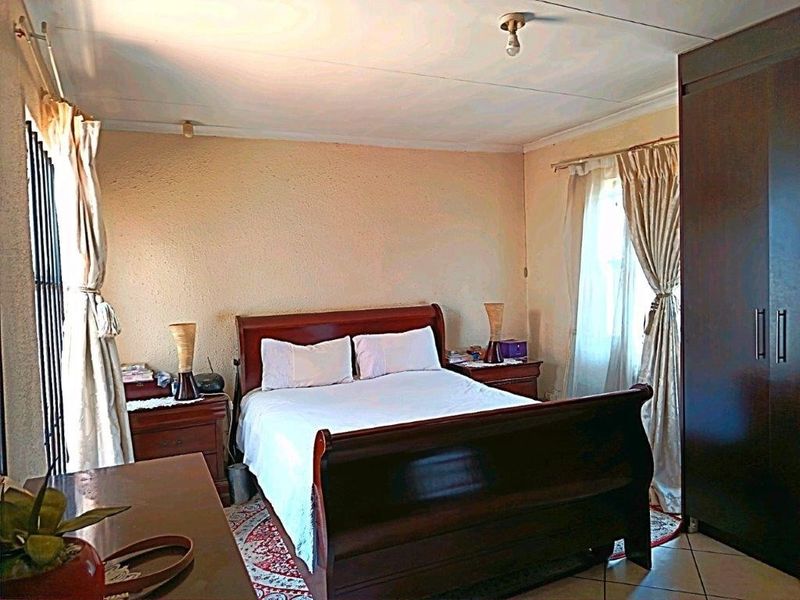 A bedroom featuring tiled flooring and a built-in wardrobe, offering a functional space with standard finishes.