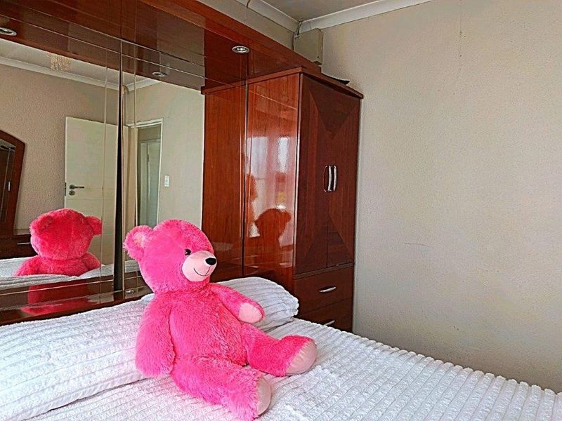 Bedroom featuring a large built-in wardrobe with integrated mirrored doors and classic coving detail.