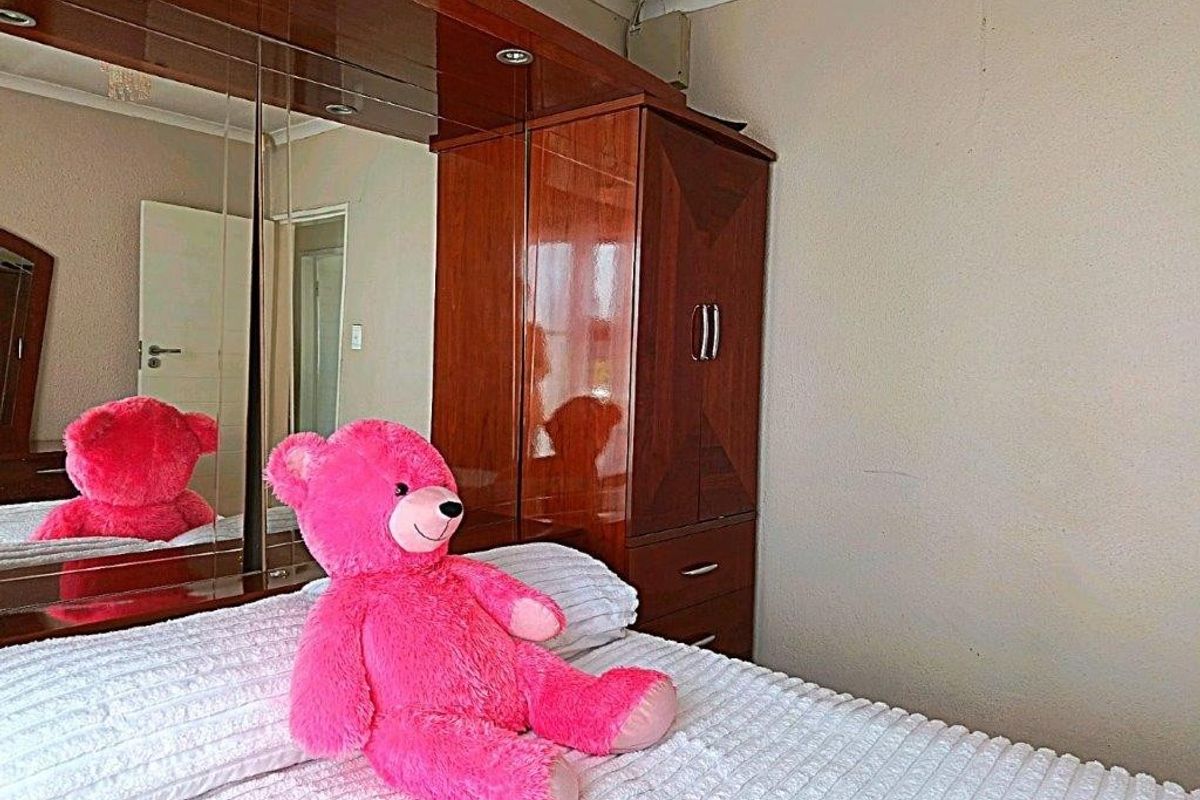 Bedroom featuring a large built-in wardrobe with integrated mirrored doors and classic coving detail.
