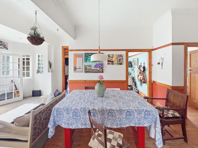 A dining area featuring original timber flooring, classic timber door frames, and a decorative dado rail, creating a warm and character-filled living space.