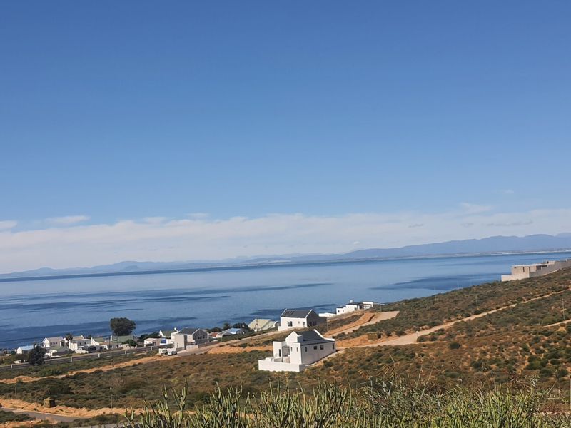 A scenic elevated view overlooking the coastline, ocean, and surrounding residential development in a coastal setting.