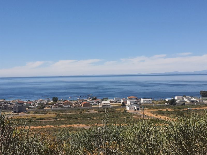 A scenic elevated view overlooking the coastal landscape, residential area, and the ocean horizon.