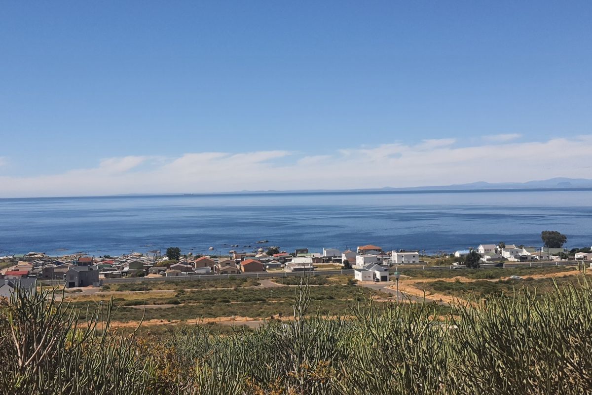 A scenic elevated view overlooking the coastal landscape, residential area, and the ocean horizon.