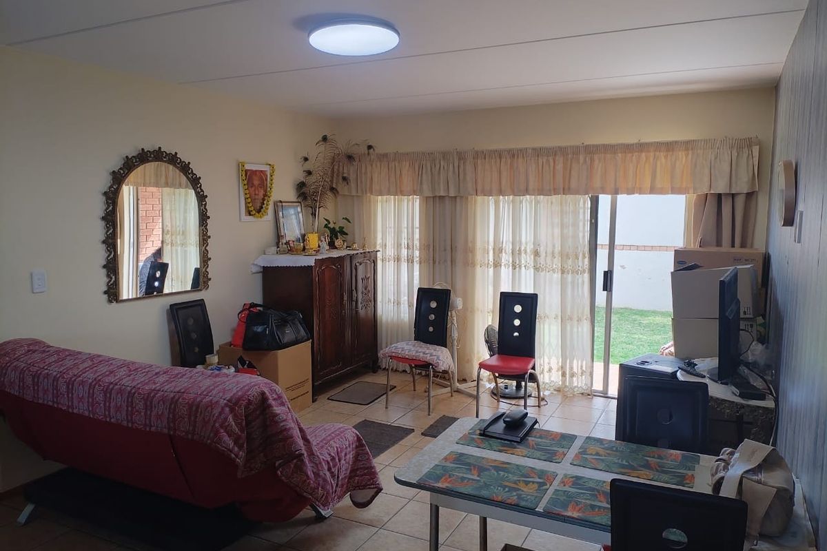 A living room area featuring tiled flooring and a sliding glass door providing access to the outdoor space.