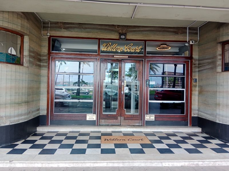 The main entrance of Willern Court features a classic checkerboard tiled porch, timber-framed glass doors, and elegant stone-clad exterior walls.