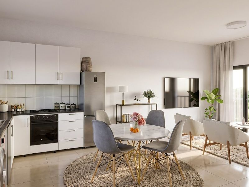 Modern open-plan living area featuring a sleek kitchen with built-in cabinetry, integrated appliances, and seamless access to an outdoor balcony through sliding glass doors.