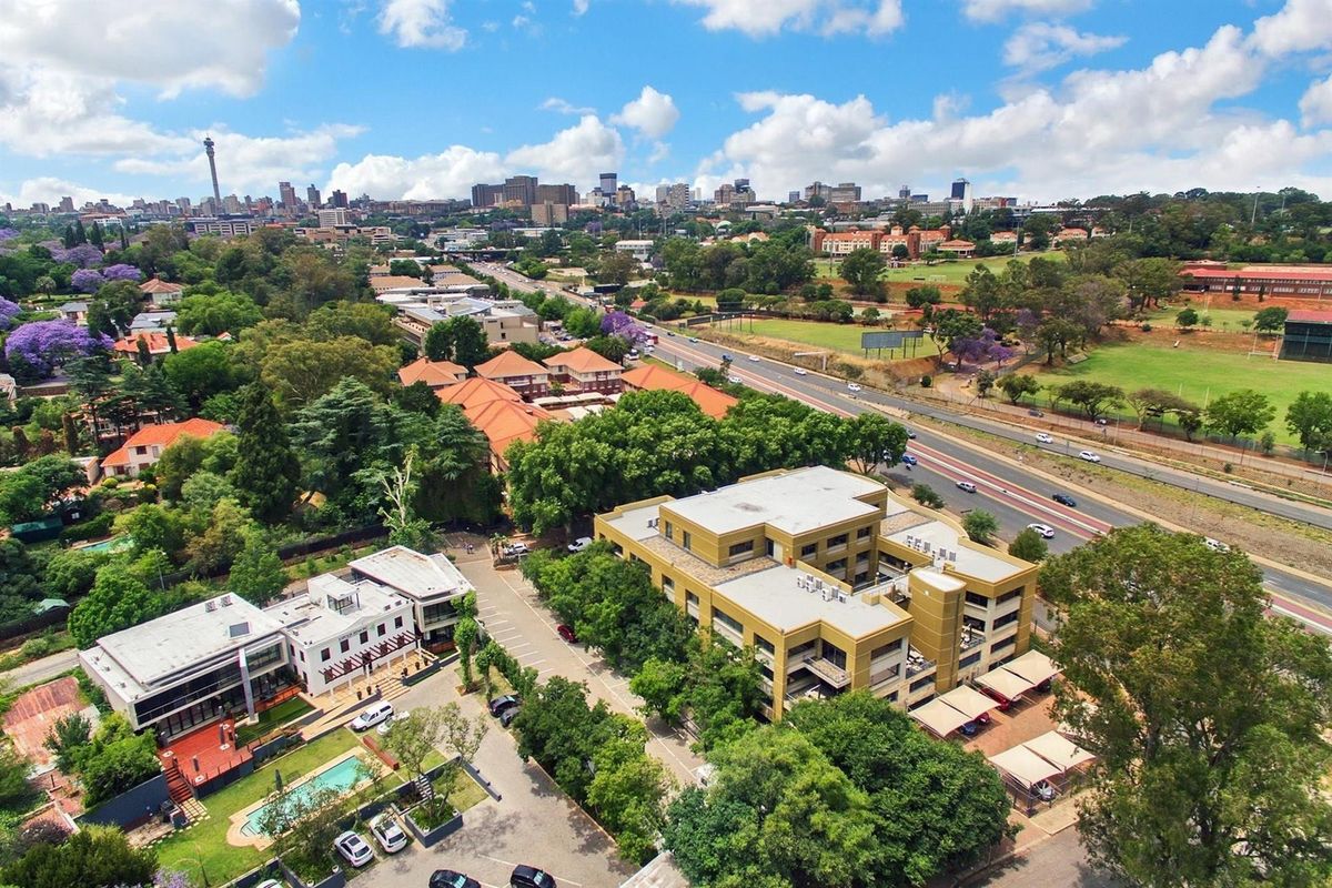 Aerial view of the office property, showcasing the building, parking facilities, and surrounding landscaped grounds within the urban environment.