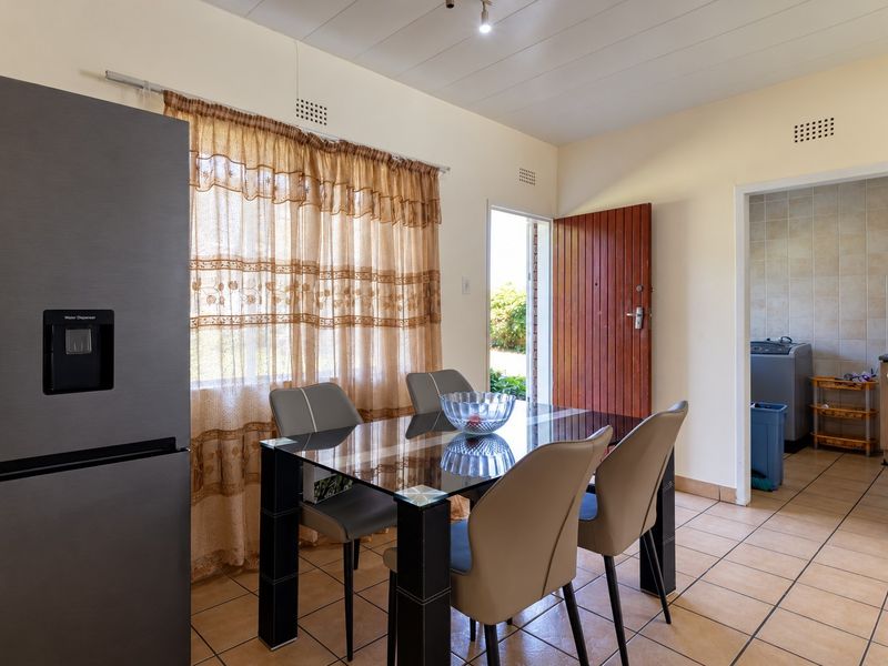Dining area featuring tiled flooring and direct access to an adjacent utility space, providing a functional layout for daily living.