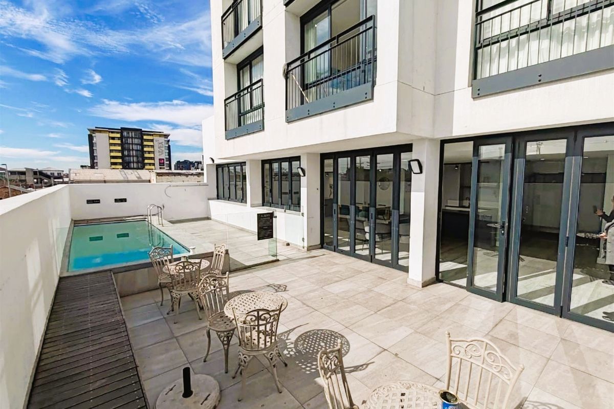 Spacious outdoor terrace featuring a swimming pool, modern tiled flooring, and direct access to the apartment interior through large bi-fold doors.