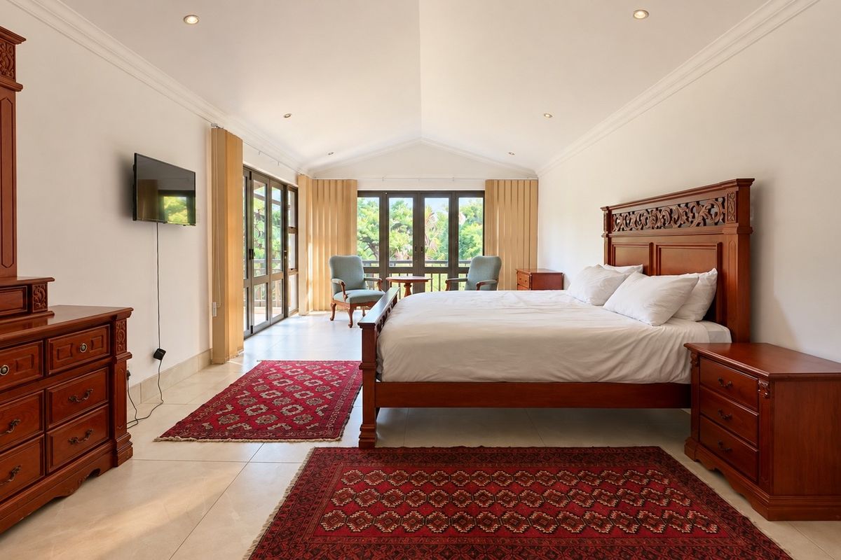 Spacious bedroom featuring a vaulted ceiling, recessed lighting, tiled floors, and large sliding glass doors providing natural light and access to the outdoors.