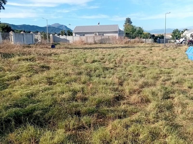 A vacant plot of land featuring perimeter fencing and views of the surrounding landscape and neighboring properties.