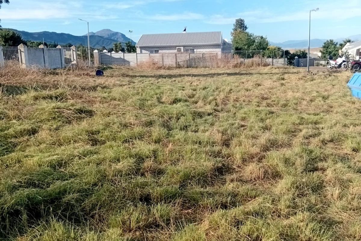 A vacant plot of land featuring perimeter fencing and views of the surrounding landscape and neighboring properties.