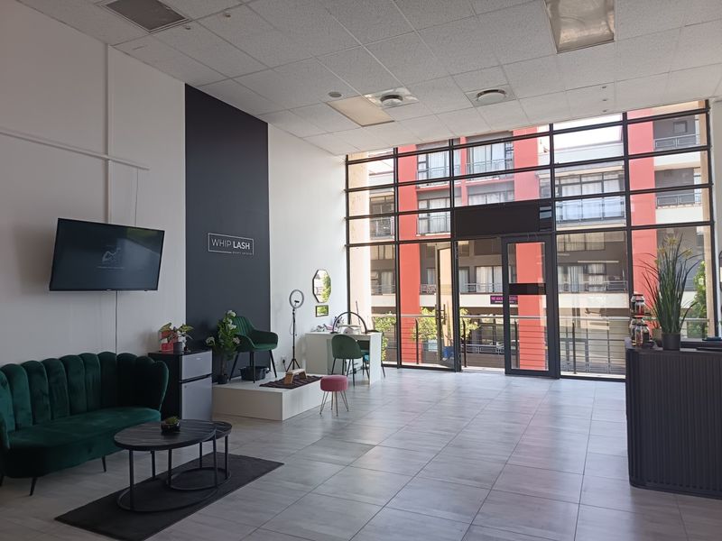 Spacious open-plan retail unit featuring large floor-to-ceiling windows, tiled flooring, and a modern suspended ceiling, providing excellent natural light and visibility.