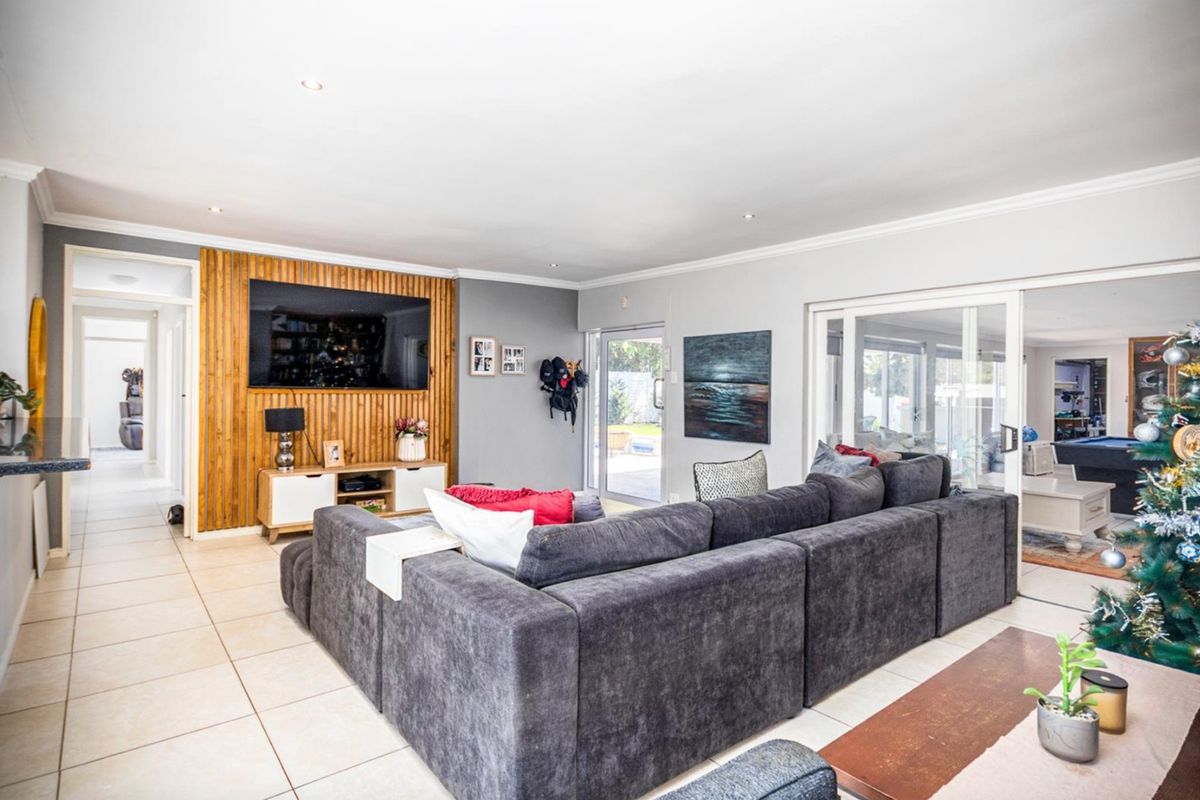 Spacious living room featuring a timber slat feature wall, tiled flooring, and large sliding glass doors providing access to the outdoor area.