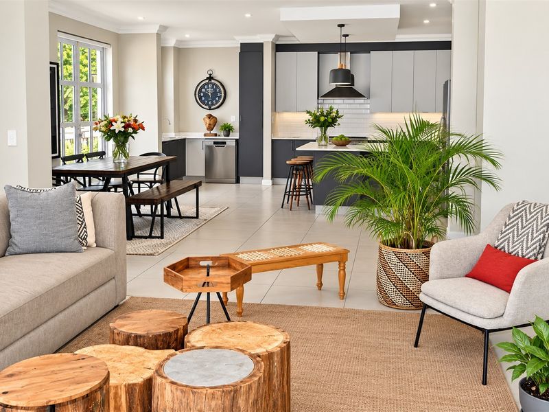 Spacious open-plan living and kitchen area featuring modern cabinetry, a central island, tiled flooring, and high-quality finishes throughout.