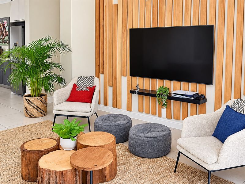 Modern living room featuring a stylish timber slat feature wall, neutral tiled flooring, and a sleek floating shelf.