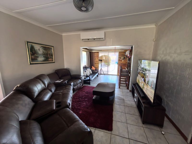 Open plan living area featuring tiled flooring, air conditioning, and a sliding door leading to an outdoor space.