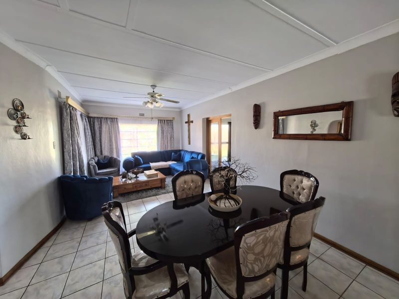 Spacious open-plan living and dining area featuring tiled flooring, a ceiling fan, and direct access to the outdoor space via a sliding door.