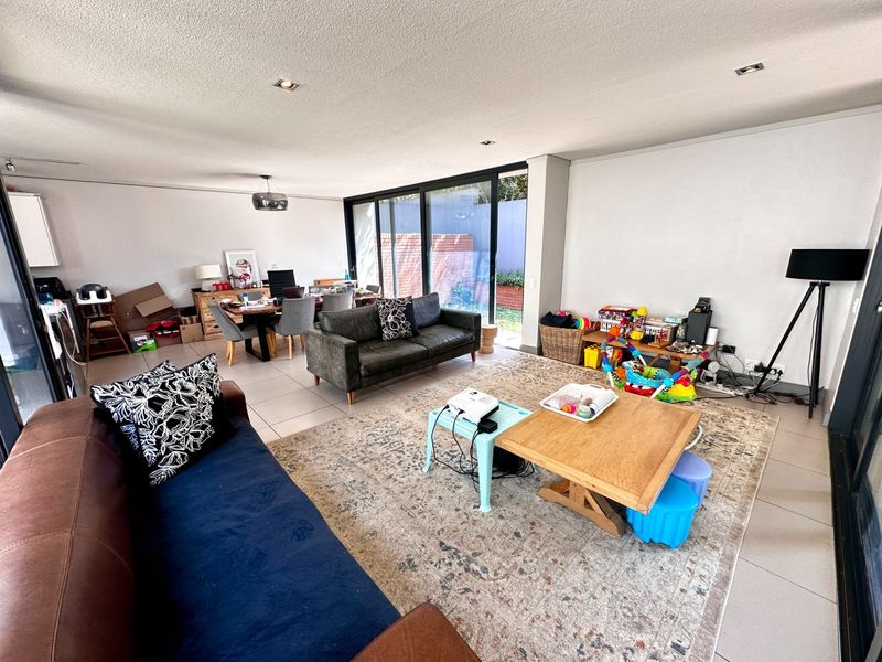 Spacious open-plan living and dining area featuring large sliding glass doors that provide ample natural light and seamless access to the outdoor space.