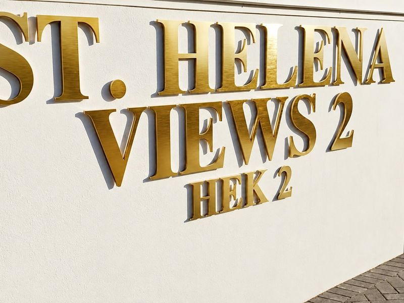 A clear view of the St. Helena Views 2 estate signage mounted on a clean, modern wall with paved ground in the foreground.