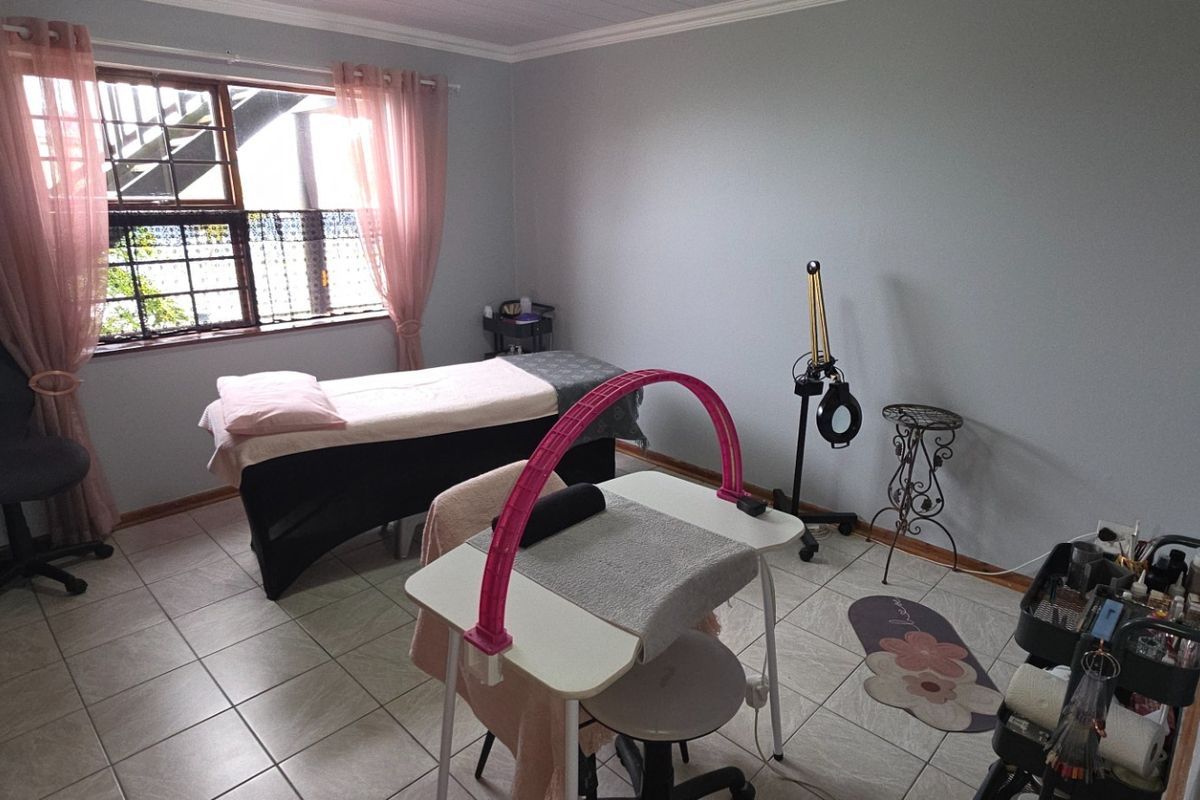 A functional bedroom space currently utilized as a beauty treatment room, featuring tiled flooring and built-in storage.