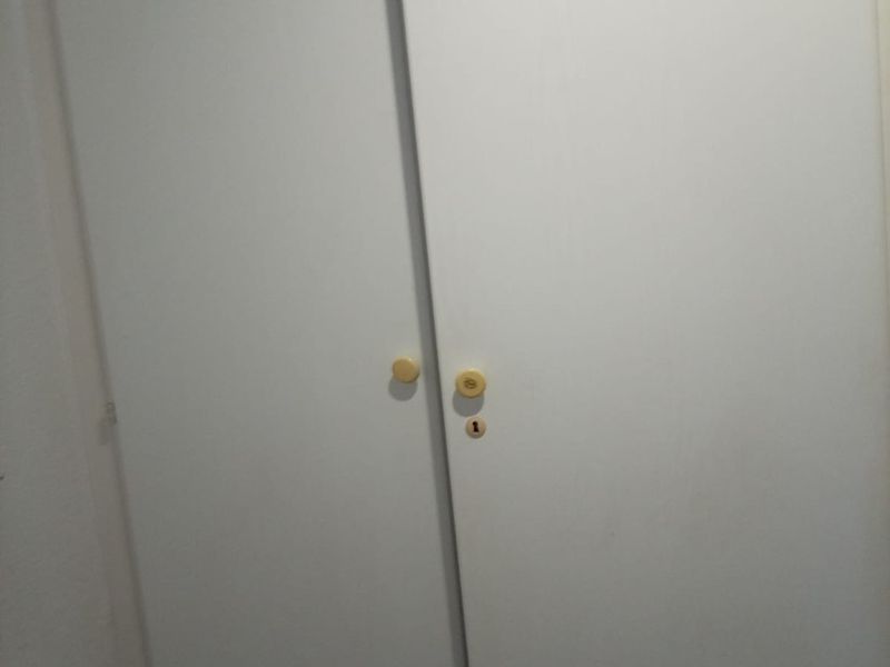 A close-up view of a standard white built-in wardrobe with simple round knobs.