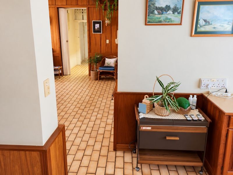 A well-maintained hallway featuring classic wood wall paneling and durable ceramic tile flooring, providing a warm and traditional aesthetic.