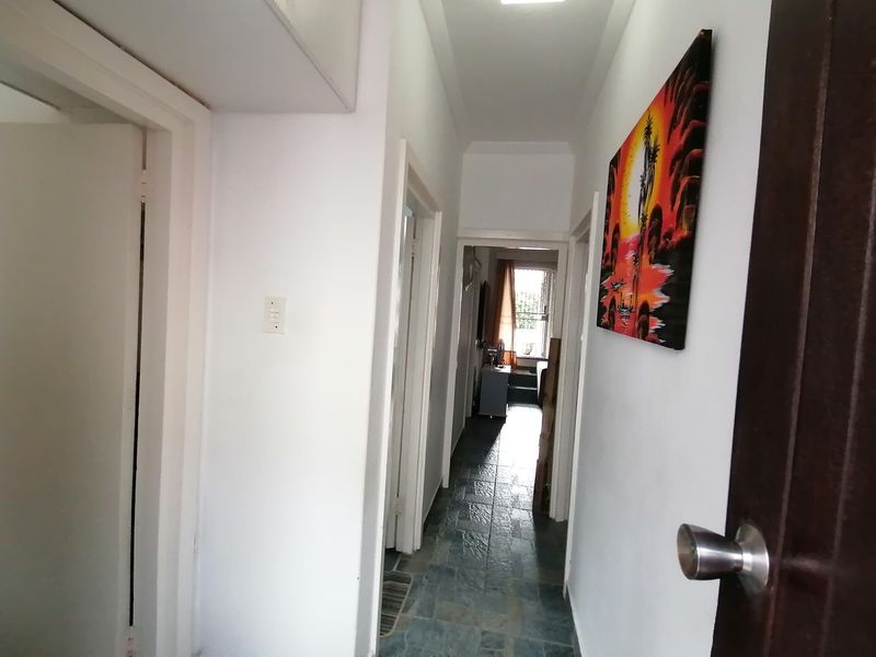 A functional hallway featuring tiled flooring and access to multiple rooms, providing a clean and neutral transition space within the apartment.