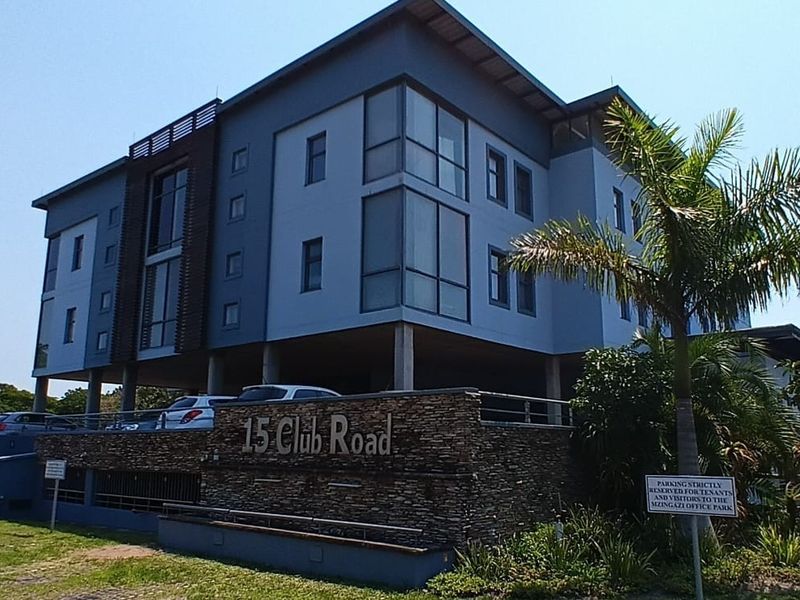 Modern multi-story office building featuring stone cladding, large glass windows, and a covered parking area at 15 Club Road.