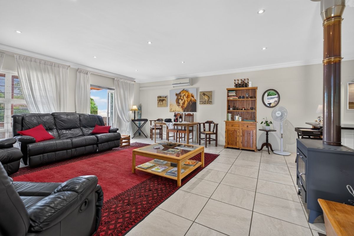 Spacious living room featuring tiled flooring, recessed downlights, a wood-burning stove, and direct access to the outdoor area through sliding glass doors.