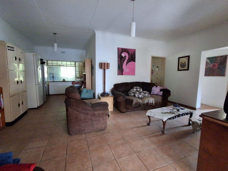 Open plan living area featuring tiled flooring and neutral walls, providing a functional space that connects to the kitchen area.
