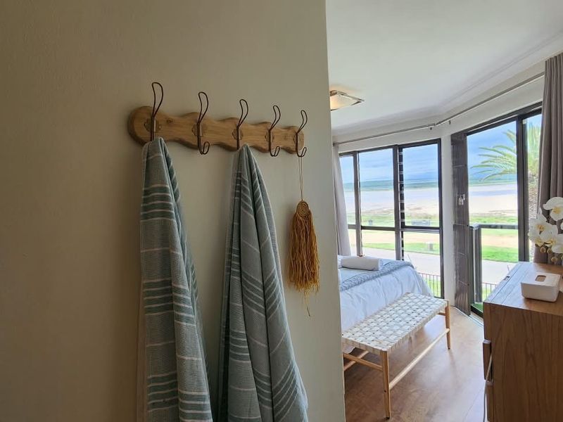 A bright bedroom featuring laminate flooring and large sliding glass doors that provide natural light and access to a balcony with scenic views.