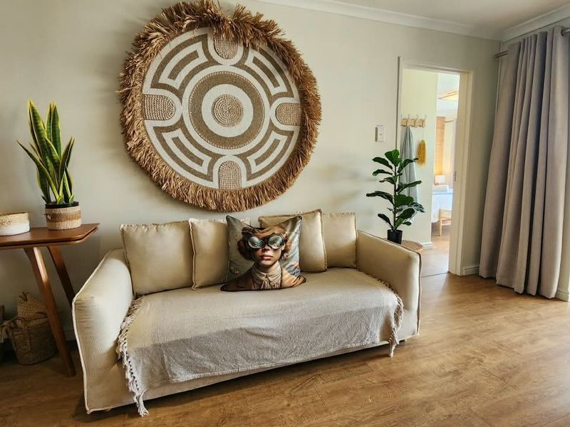 A well-maintained living room featuring laminate flooring and a sliding glass door providing access to an outdoor area.