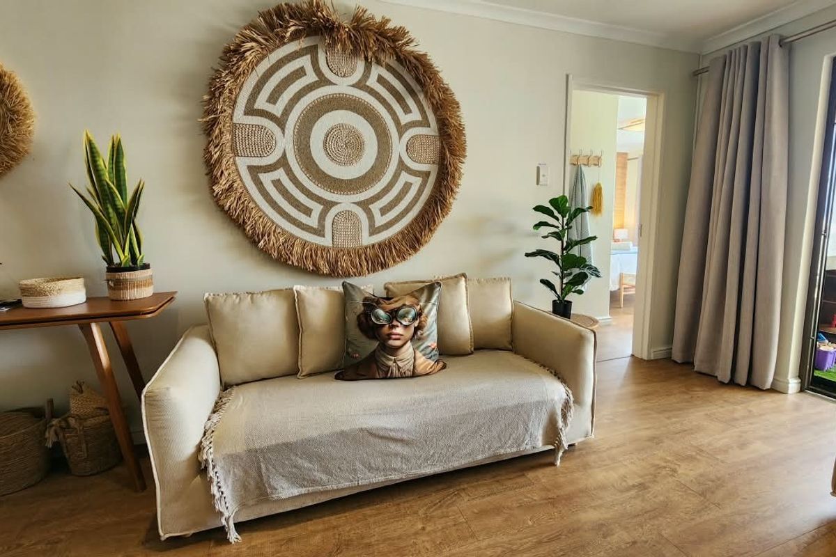 A well-maintained living room featuring laminate flooring and a sliding glass door providing access to an outdoor area.