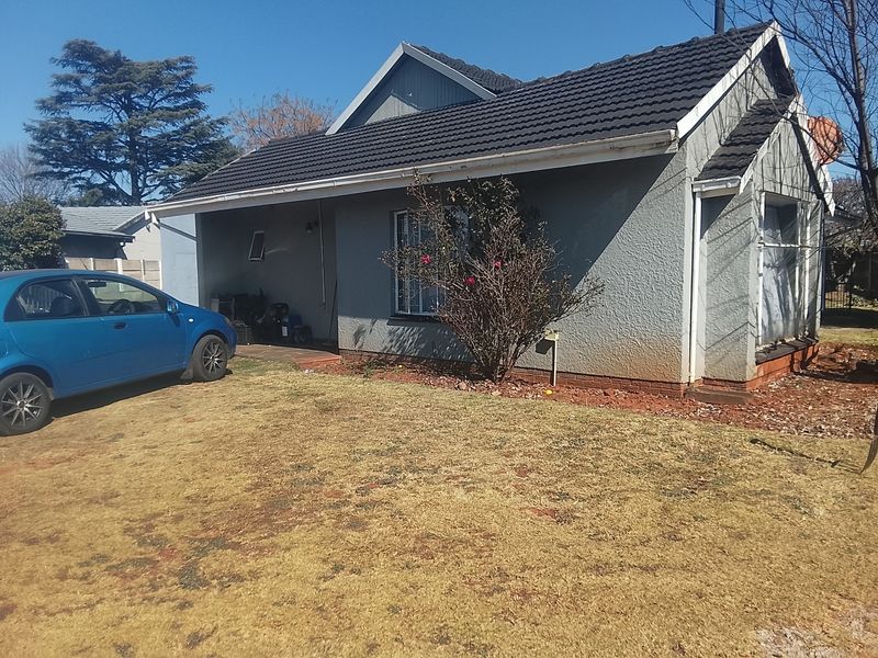 Front elevation of a single-story house featuring a tiled roof, covered entrance, and a concrete driveway.