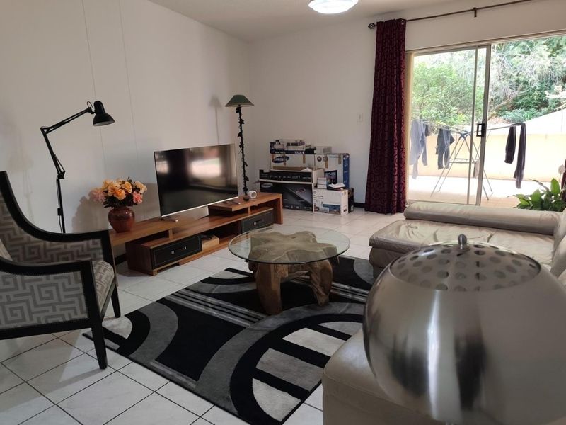 A living room featuring tiled flooring and a sliding glass door providing access to an outdoor area.