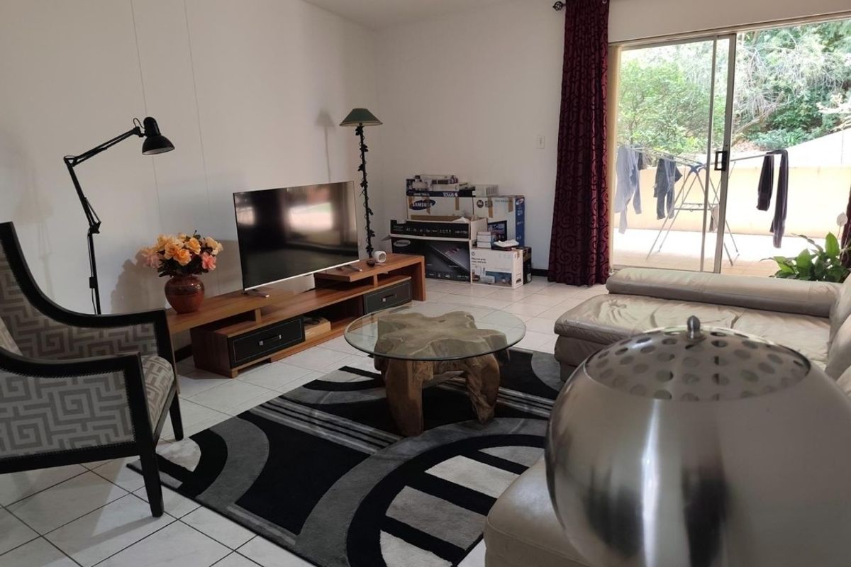 A living room featuring tiled flooring and a sliding glass door providing access to an outdoor area.