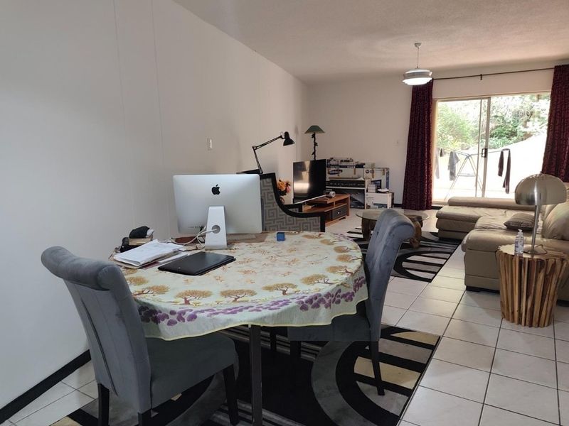 Open plan living and dining area featuring tiled flooring and a sliding glass door providing access to the outdoor space.