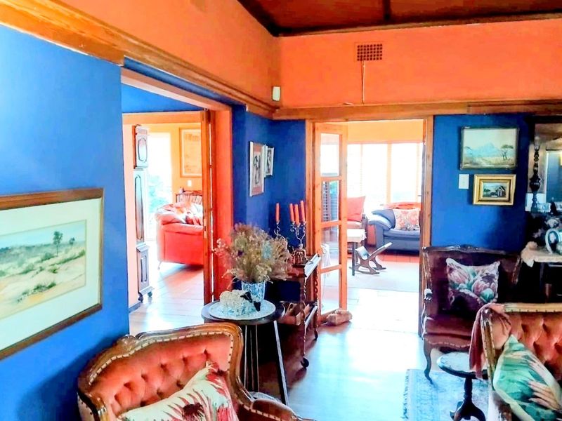 A living room featuring timber door frames and a timber ceiling, with an open layout connecting to adjacent living spaces.
